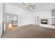 Spacious living area with a fireplace, neutral carpet, and staircase access to other rooms at 8970 Lansberry Ct, Las Vegas, NV 89147