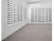 Bright living room has neutral carpet and large windows with privacy shutters at 8970 Lansberry Ct, Las Vegas, NV 89147