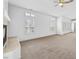 Open living room with neutral carpet, a tile-surround fireplace, and shuttered windows at 8970 Lansberry Ct, Las Vegas, NV 89147