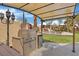 Outdoor kitchen featuring a stainless steel grill and beverage fridge, with a view of the pool area at 8970 Lansberry Ct, Las Vegas, NV 89147