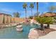 Inviting pool with rock features, slide, and tiki hut providing shade, set against a clear blue sky at 8970 Lansberry Ct, Las Vegas, NV 89147