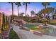 Backyard pool oasis features a waterfall, waterslide, rock features, and a tiki hut at 8970 Lansberry Ct, Las Vegas, NV 89147