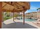 View from underneath the tiki hut overlooking the pool and lush backyard, perfect for outdoor relaxation at 8970 Lansberry Ct, Las Vegas, NV 89147