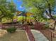 Community playground features a slide, climbing structures, and a shaded area for children at 9116 Tailor Made Ave, Las Vegas, NV 89149