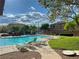 Community pool area surrounded by lounge chairs and well-maintained landscaping at 9116 Tailor Made Ave, Las Vegas, NV 89149