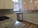 Bright kitchen boasts stainless appliances, granite counters, mosaic backsplash, and natural light at 9329 Fresh Spring Dr, Las Vegas, NV 89134