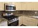 Well-equipped kitchen with stainless steel appliances, granite countertops and stylish mosaic backsplash at 9329 Fresh Spring Dr, Las Vegas, NV 89134