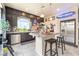 Modern kitchen with island, dark cabinets, stainless steel appliances, and attractive tile floors at 9704 Morgan Creek Ct, Las Vegas, NV 89141