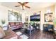 Comfortable living room with hardwood floors, ceiling fan, and a large television for entertainment at 9704 Morgan Creek Ct, Las Vegas, NV 89141