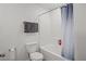 Clean bathroom with a shower and tub combo featuring white tile, a grey towel, and neutral walls at 9929 Bumblebee Hills St, Las Vegas, NV 89141