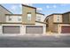 Three modern townhomes each featuring two-car garages and contemporary architectural design under a blue sky at 9929 Bumblebee Hills St, Las Vegas, NV 89141
