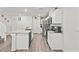 Modern kitchen with white cabinets, stainless steel appliances, quartz countertops and wood-look floors at 9929 Bumblebee Hills St, Las Vegas, NV 89141