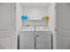 Convenient laundry room with a white washer and dryer and shelving for storage at 9929 Bumblebee Hills St, Las Vegas, NV 89141