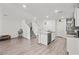 Open-concept living area with wood-look floors, white walls, and a staircase leading to the upper level at 9929 Bumblebee Hills St, Las Vegas, NV 89141