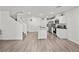 Open-concept living and kitchen area with hardwood floors, bright lighting, and a modern staircase at 9929 Bumblebee Hills St, Las Vegas, NV 89141