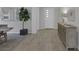 Inviting entryway with wood-look tile flooring, a modern cabinet, a mirror, and a leafy potted plant at , Las Vegas, NV 89148