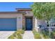 Close-up of a modern home featuring a stylish blue front door with stone accents and lush landscaping at , Las Vegas, NV 89148