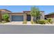 Charming single-story home with a blue door, blue garage door, a small tree, and manicured landscaping at , Las Vegas, NV 89148