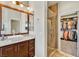 Bathroom featuring double vanity, glass shower, and walk-in closet with custom shelving for optimal organization at 10420 Loma Portal Ave, Las Vegas, NV 89166