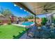 Inviting covered patio next to a backyard pool, with outdoor seating, perfect for relaxing and enjoying the view at 10420 Loma Portal Ave, Las Vegas, NV 89166