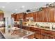 Modern kitchen featuring stainless appliances, a granite island, and dark wood cabinetry at 10420 Loma Portal Ave, Las Vegas, NV 89166