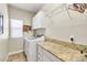 Well-organized laundry room with granite counters, overhead cabinets, and modern washer and dryer at 10420 Loma Portal Ave, Las Vegas, NV 89166