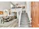 Bright, open living room with high ceilings, carpeted staircase, and elegant dining set at 10420 Loma Portal Ave, Las Vegas, NV 89166