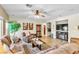 Spacious living room featuring a ceiling fan, couches, and a fireplace at 10420 Loma Portal Ave, Las Vegas, NV 89166