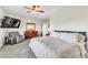 Comfortable main bedroom featuring a ceiling fan, TV, recliner and dresser with a large framed mirror at 10420 Loma Portal Ave, Las Vegas, NV 89166
