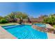 Inviting pool and spa featuring beautiful stonework and landscaping, creating a serene outdoor retreat at 10420 Loma Portal Ave, Las Vegas, NV 89166