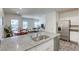 Open-concept kitchen with stainless steel appliances and granite countertops overlooking the living area at 12728 Feathersong St, Henderson, NV 89044