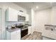 Bright kitchen featuring white cabinets, stainless steel appliances, gray countertops, and hardwood floors at 12728 Feathersong St, Henderson, NV 89044