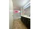 Bathroom with a shower and a vanity sink with dark cabinets and tile floor at 1533 Linnbaker Ln # 102, Las Vegas, NV 89110