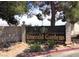 Entrance sign for Emerald Gardens neighborhood featuring manicured landscaping and established trees at 1533 Linnbaker Ln # 102, Las Vegas, NV 89110