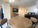 Open concept dining area leading to the living room with a round wooden table set at 1533 Linnbaker Ln # 102, Las Vegas, NV 89110