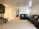 A spacious living room with neutral carpet, a comfortable dark leather sofa set, and a ceiling fan at 1533 Linnbaker Ln # 102, Las Vegas, NV 89110