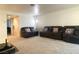 A living room with neutral carpet, a dark leather sofa set and an open concept layout at 1533 Linnbaker Ln # 102, Las Vegas, NV 89110