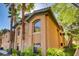 Beautiful condo building featuring desert landscaping with mature palm trees and lovely stucco at 1713 Sky Of Red Dr # 203, Las Vegas, NV 89128