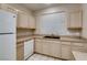 Bright kitchen featuring light wood cabinets, tile flooring and a white dishwasher and refrigerator at 1713 Sky Of Red Dr # 203, Las Vegas, NV 89128