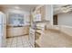 Kitchen featuring tile flooring, light wood cabinetry, granite countertops, and white appliances at 1713 Sky Of Red Dr # 203, Las Vegas, NV 89128