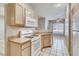 Kitchen featuring light wood cabinets, a white microwave, and a gas range at 1713 Sky Of Red Dr # 203, Las Vegas, NV 89128