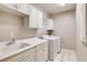 Functional laundry room features tile floors, washer, dryer, sink, and built-in white storage cabinets at 1713 Sky Of Red Dr # 203, Las Vegas, NV 89128