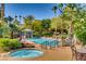 Resort-style pool area with hot tub, lounge chairs, umbrellas, and lush tropical landscaping at 1713 Sky Of Red Dr # 203, Las Vegas, NV 89128
