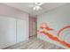Bedroom with closet and a unique mural, ceiling fan, and wood-look flooring at 1829 Fighting Falcon Ln, North Las Vegas, NV 89031