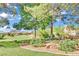 Serene backyard with mature trees, a charming sitting area, and views of the golf course and mountains at 1984 Troon Dr, Henderson, NV 89074