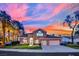 Charming two-story home with well-manicured lawn and mature palm trees, set against a vibrant sunset sky at 1984 Troon Dr, Henderson, NV 89074