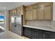 Modern kitchen featuring stainless steel refrigerator, two-tone cabinets, and light countertops at 1984 Troon Dr, Henderson, NV 89074