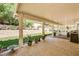 Spacious covered patio featuring stone tile, outdoor seating, a grill, and a landscaped backyard at 2036 Deer Springs Dr, Henderson, NV 89074