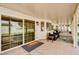 Covered patio with tiled flooring, outdoor seating, and a well-maintained backyard view through large sliding glass doors at 2036 Deer Springs Dr, Henderson, NV 89074
