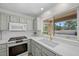 Kitchen with gray cabinets, quartz countertops, modern appliances, and large window overlooking the backyard at 2216 Spring Water Dr, Las Vegas, NV 89134